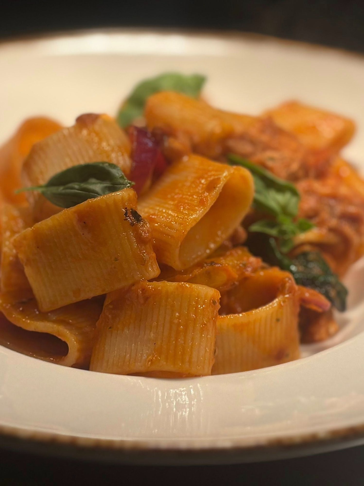 Rigatoni pasta with rich Amatriciana tomato sauce and fresh basil