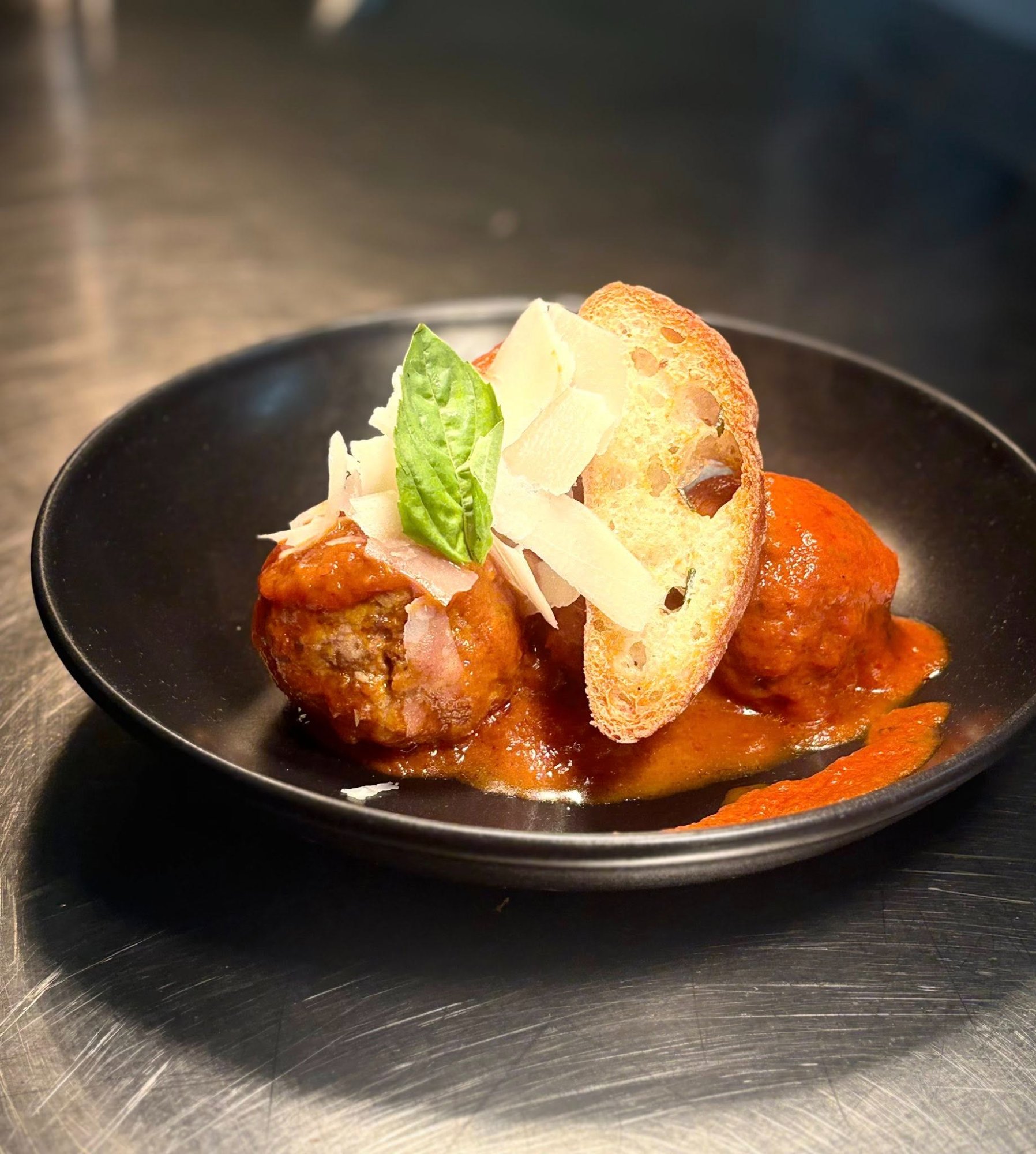 Meatballs in tomato sauce with parmesan and crostini